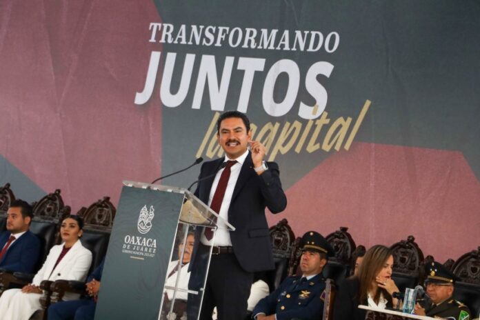 Oaxaca mayor Raymundo Chagoya speaking at a podium with 