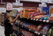 Post-AMLO, Mexican household income is up and inequality is slightly down A woman takes a product off a grocery store shelf