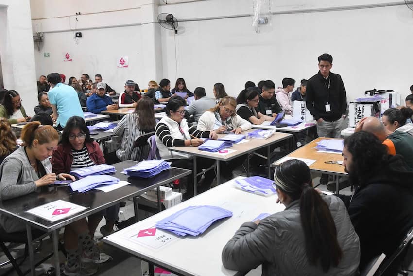 People at tables counting votes