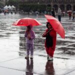 Heavy June rains reduce Mexico’s drought-affected territory by 13% 2 people with rain umbrellas