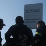 Nissan announces plans to close its historic Cuernavaca plant, moving production to Aguascalientes silhouetted figure in front of a Nissan sign