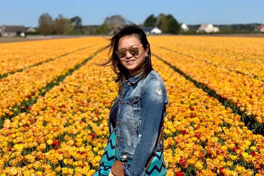A woman standing in a field of tulips