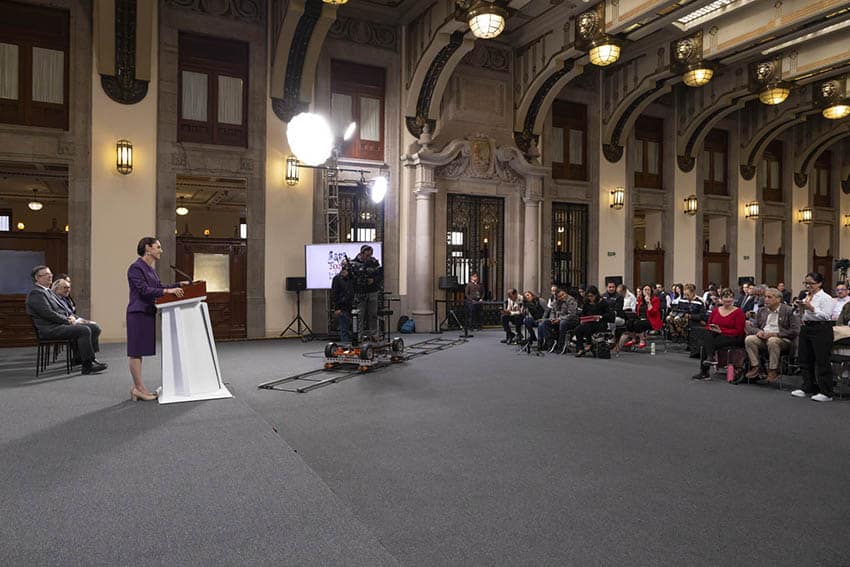 Sheinbaum stands in front of a room full of reporters