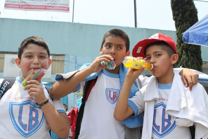 Three schoolboys drinking sugared drinks
