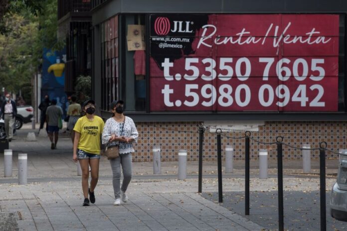 two people walkin gby a for rent sign