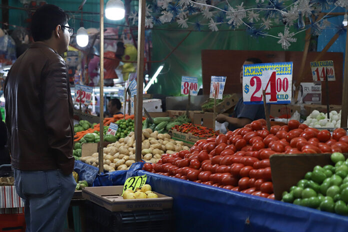 A man looks at produce in a Mexican market