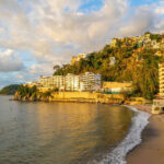 MND Local: Puerto Vallarta news roundup Coastal view of a sandy beach with resorts and hillside homes in Puerto Vallarta, Mexico.