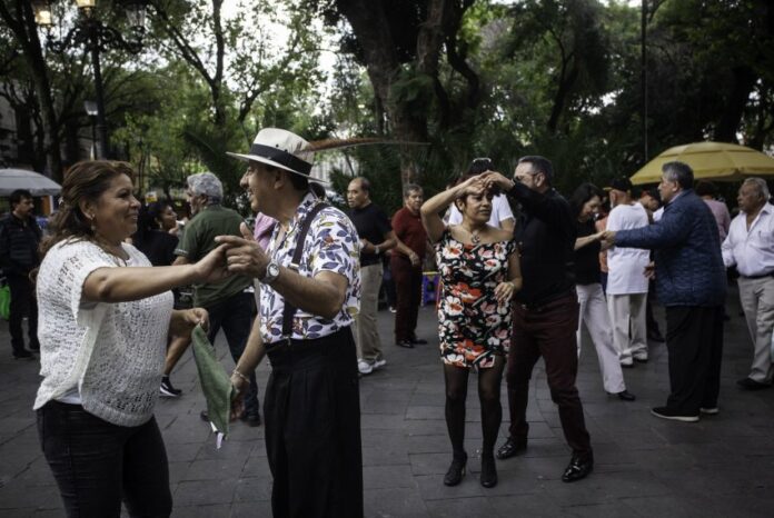 Pairs of middle-aged Mexican couples dancing in a public park in Mexico City.
