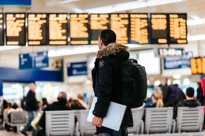 A man staring at airport departure boards.
