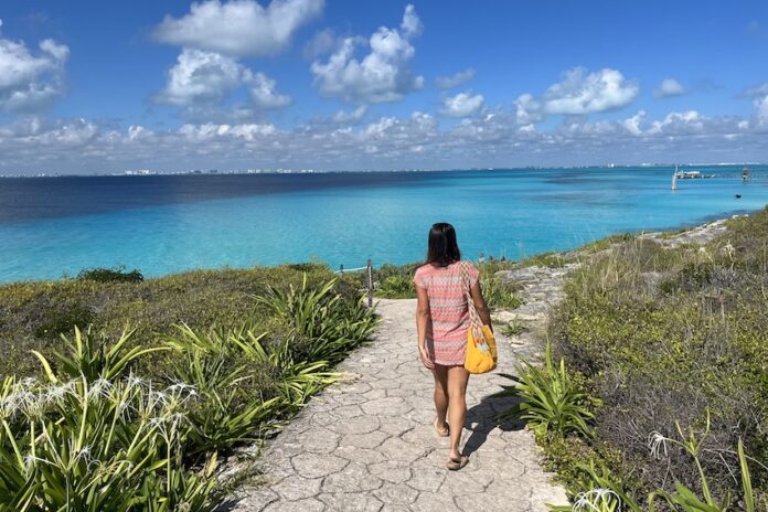 Nellie Huang walking on a cliffside path in the Riviera Maya