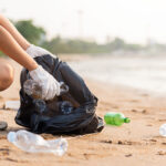 National Beach Cleanup Strategy aims to eliminate plastic pollution A woman picks up plastic bottles on a beach