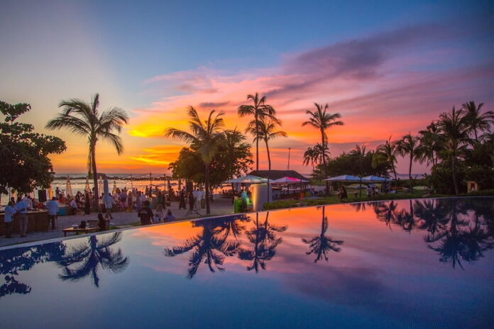 Sunset skies at a beach club in Punta Mita, where elegant tents and umbrellas shade guests by the ocean.