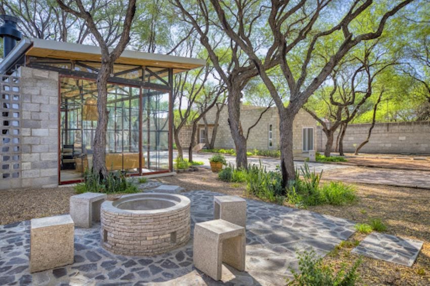 A courtyard in Mexico featuring stone and glass buildings at either ends.