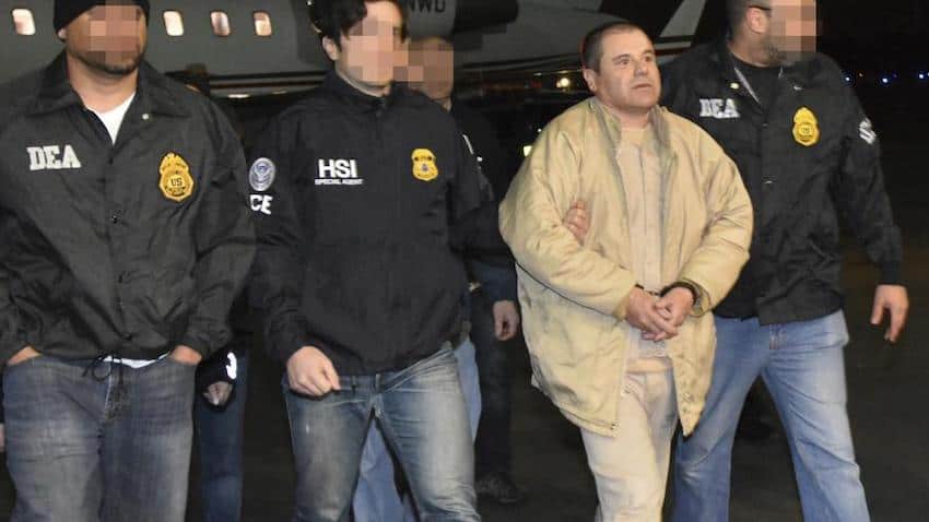 El Chapo wearing handcuffs, escorted by police