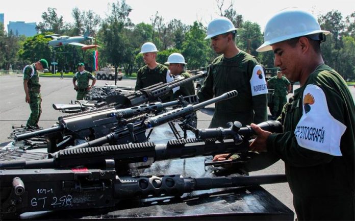 Soldiers destroy seized firearms.