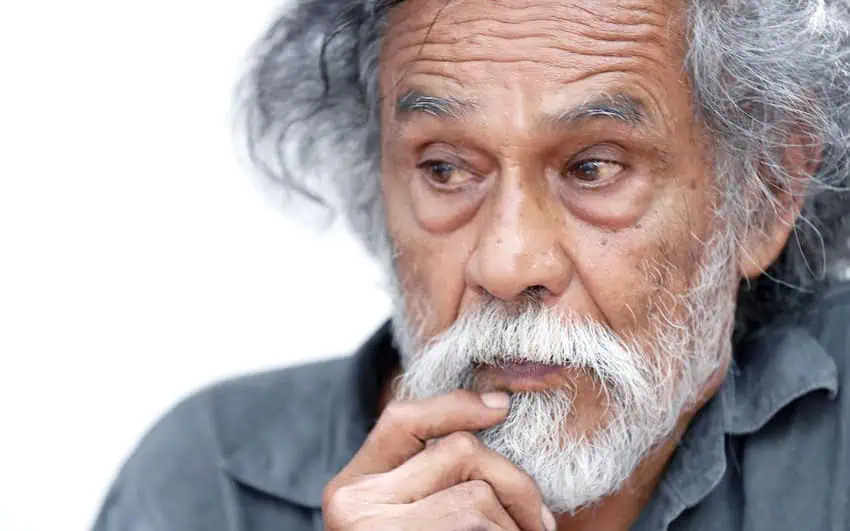 A portrait of Francisco Toledo stroking his white beard