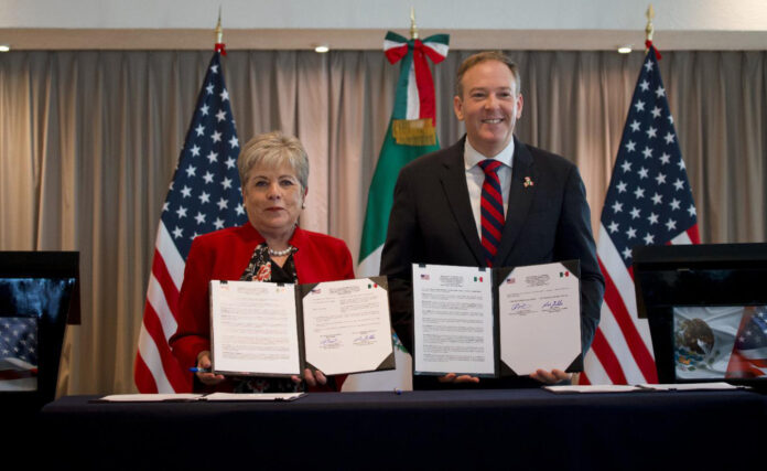 Alicia Bárcena and Zeldin hold up copies of a signed agreement to fund sewage treatment for the Tijuana River