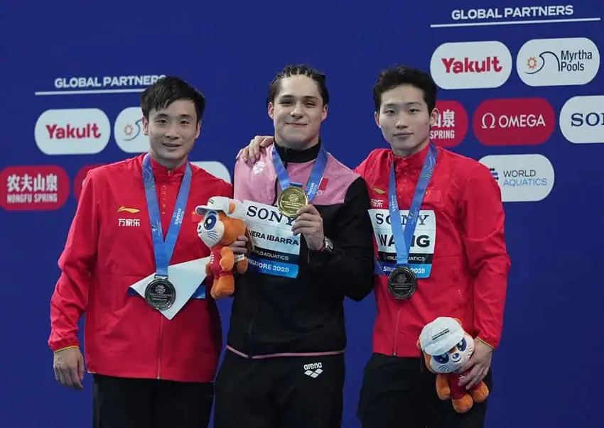 Two Chinese divers in red jackets flank champion Mexicandiver Osmar Olvera. All three hold medals