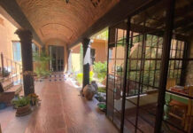 The fun, friendly and frugal way to travel within (and outside) Mexico A colonial-style covered corridor with terracotta tile floors, arched brick ceilings, and large windows overlooking a courtyard garden in San Miguel de Allende.