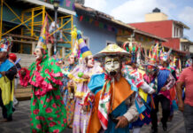 La Xiqueñada: A first-timer’s guide to Xico’s raucous weeks-long festival Costumed dancers in vibrant masks and traditional clothing parade through the streets during a Mexican festival in Xico, Veracruz, with colorful banners and colonial buildings in the background.