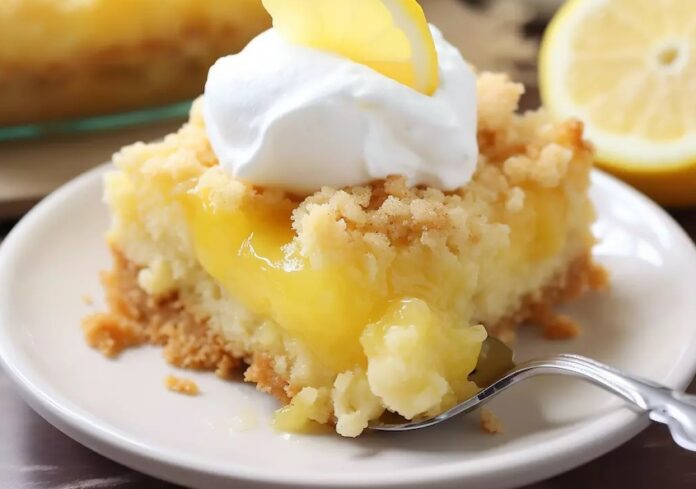 A slice of lemon cake with whipped cream and a fork