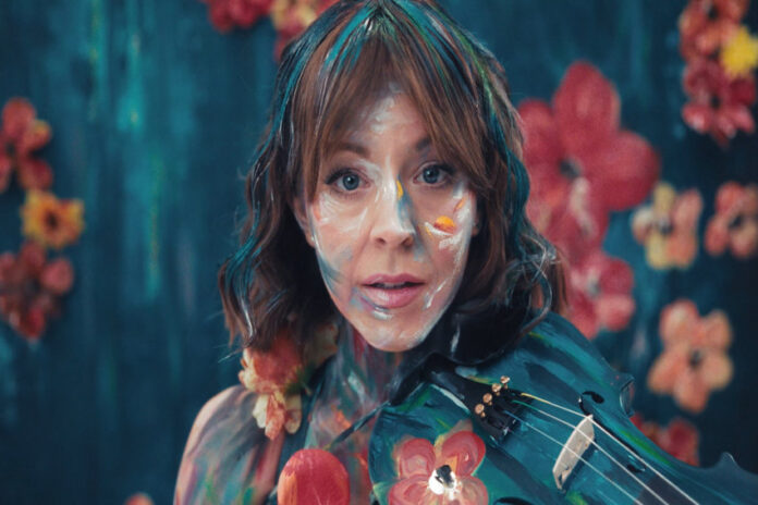 Lindsay Stirling performs with her violin amid colorful floral projections in the romo shot for The Duality Tour, which she brings to Guadalajara's Auditorio Telmex on August 6.