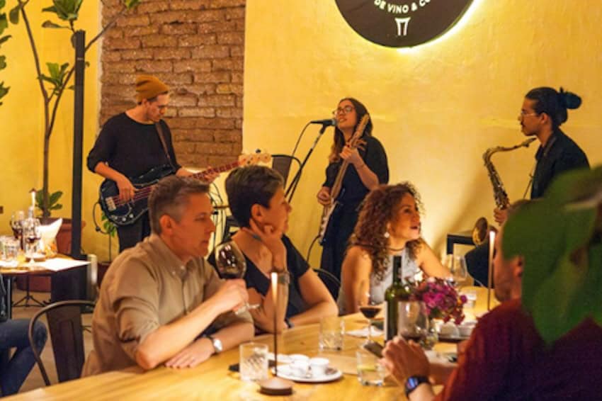 Drinkers at a bar being serenaded by live music