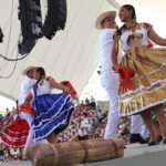 Guelaguetza kicks off in Oaxaca with performances and the festival’s first ‘Monday on the Hill’ Dancers in traditional garb including long colorful skirts dance on a stage a Guelaguetza in Oaxaca