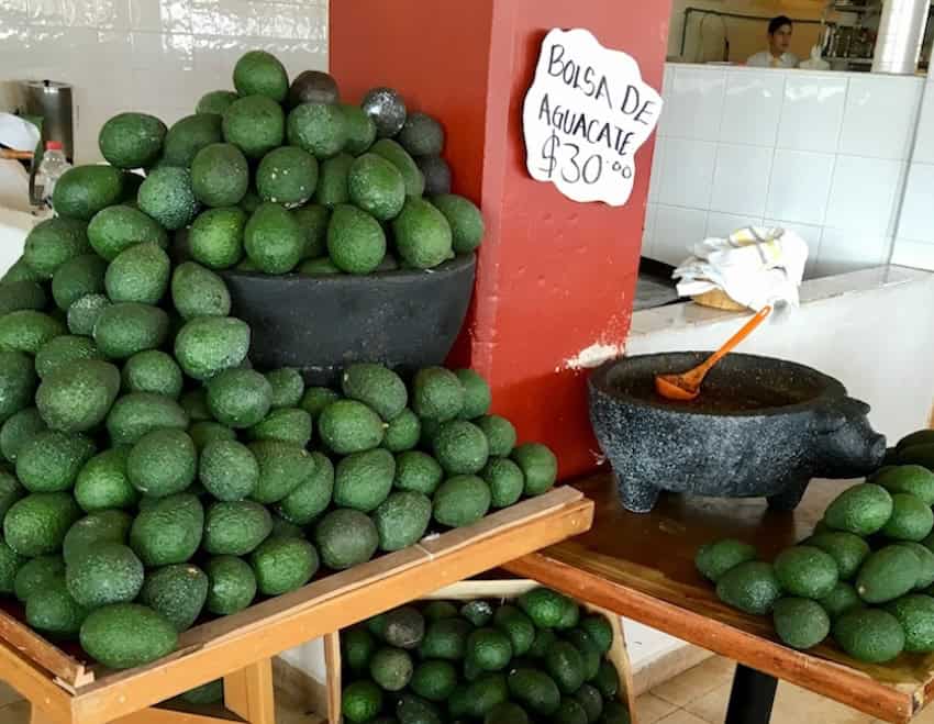 avocados at a market stand