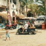 Nayarit expects a million visitors this summer, bringing a 5-billion-peso boost to its economy golf cart, people and buidlings of a Nayarit town