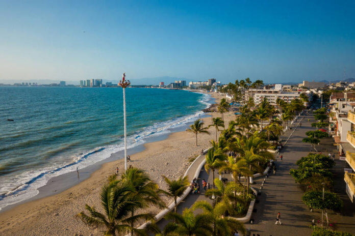 A view from high up over a beach of Puerto Vallarta's coastline and the various hotels and other buildings that ring the coast.