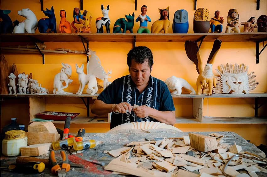 Jacobo Ángeles carving wood in his workshop