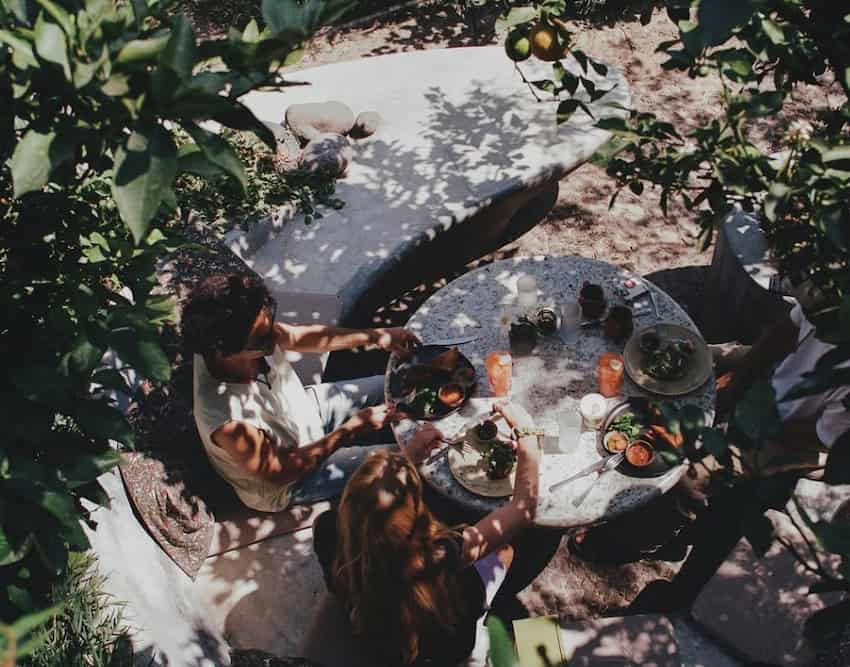 A couple eat and drink in a garden restaurant.