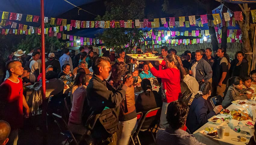A family hosts a celebration in Oaxacan in which neighbors and community eat together and enjoy a meal