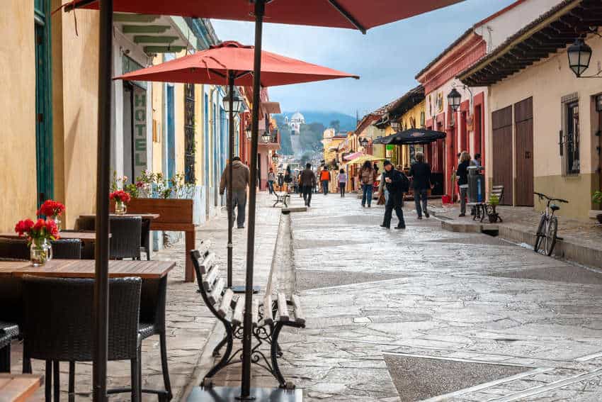 Typical street of in San Cristobal de las Casas, Chiapas, with colorful colonial architecture, narrow cobblestone streets and the Church of Our Lady of Guadalupe on top of a hill