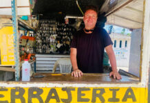Trading Zihuatanejo’s bustle for a quieter life in a small Mexican town A man with a smiling expression and sunglasses pushed up on his head stands behind a counter at an outdoor key-making stand. Behind him, numerous keys are hanging, and the word "CERRAJERIA" (locksmith) is visible on the counter in yellow letters.