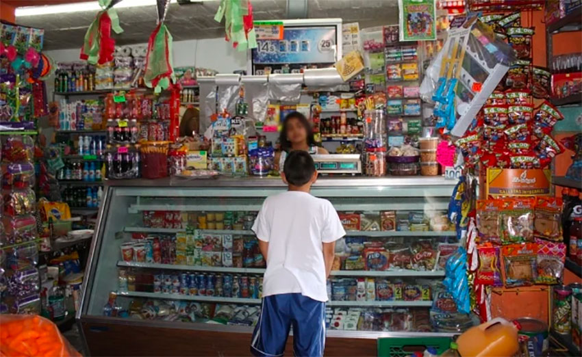 A child makes a purchase at a Mexican tiendita or corner store