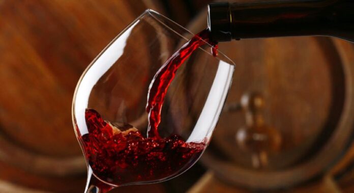 Red wine pours into a glass