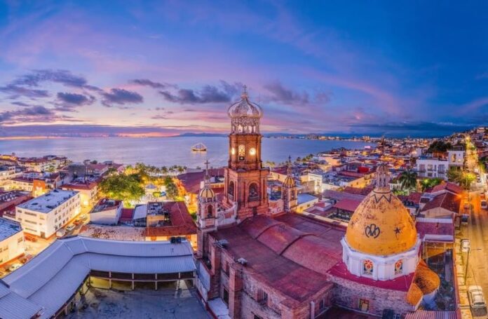 Skyline of Puerto Vallarta, with the Pacific Ocean in the background and buildings with Arabic-style domes in the foreground.