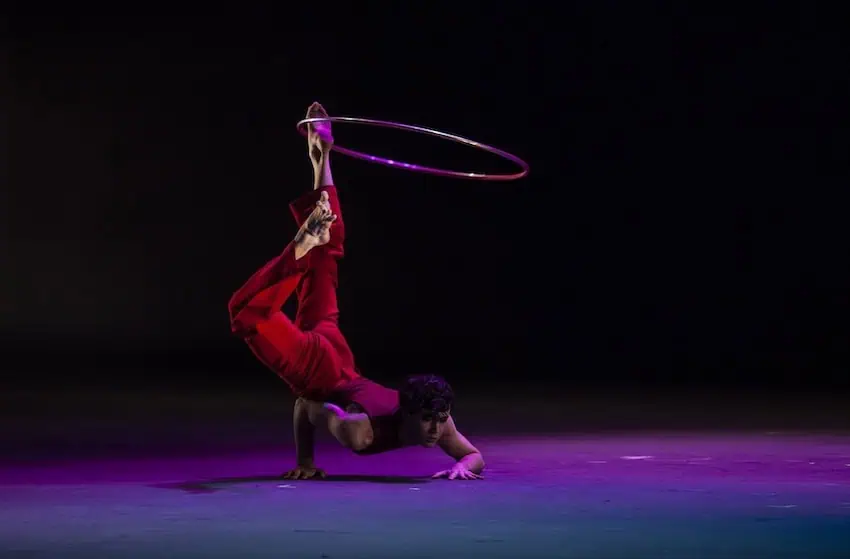A circus performer spinning a hoop on his leg