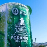 MND Local: Baja California news roundup A massive 'Margarita Cachanilla' statue in Tijuana, Mexico. resembling an oversized cocktail cup, with the words "Guinness World Records Official Attempt" visible, promoting "La Margarita Más Grande del Mundo' (The World's Largest Margarita). The structure stands under a clear blue sky with the Tijuana skyline in the background.